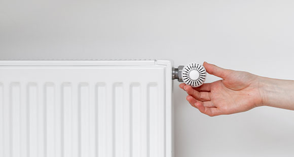 a person adjusting the temperature of their radiator 