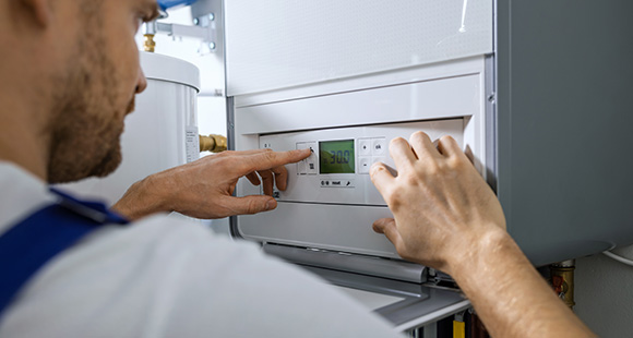 a man setting up a gas boiler in a home