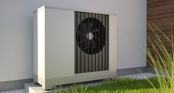 a heat pump installed outside a property against a white wall