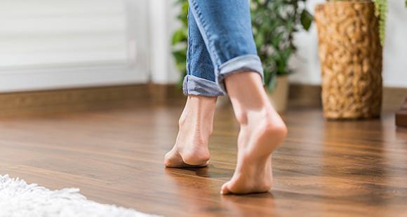a woman walking over warmed floors from underfloor heating in her home