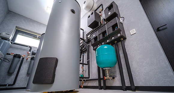a water cylinder connected to an electric boiler in a room